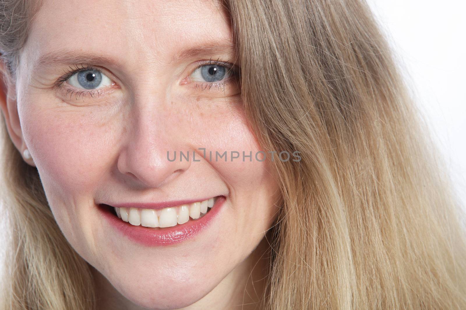 Close up of an attractive woman with blue eyes smiling at the camera.