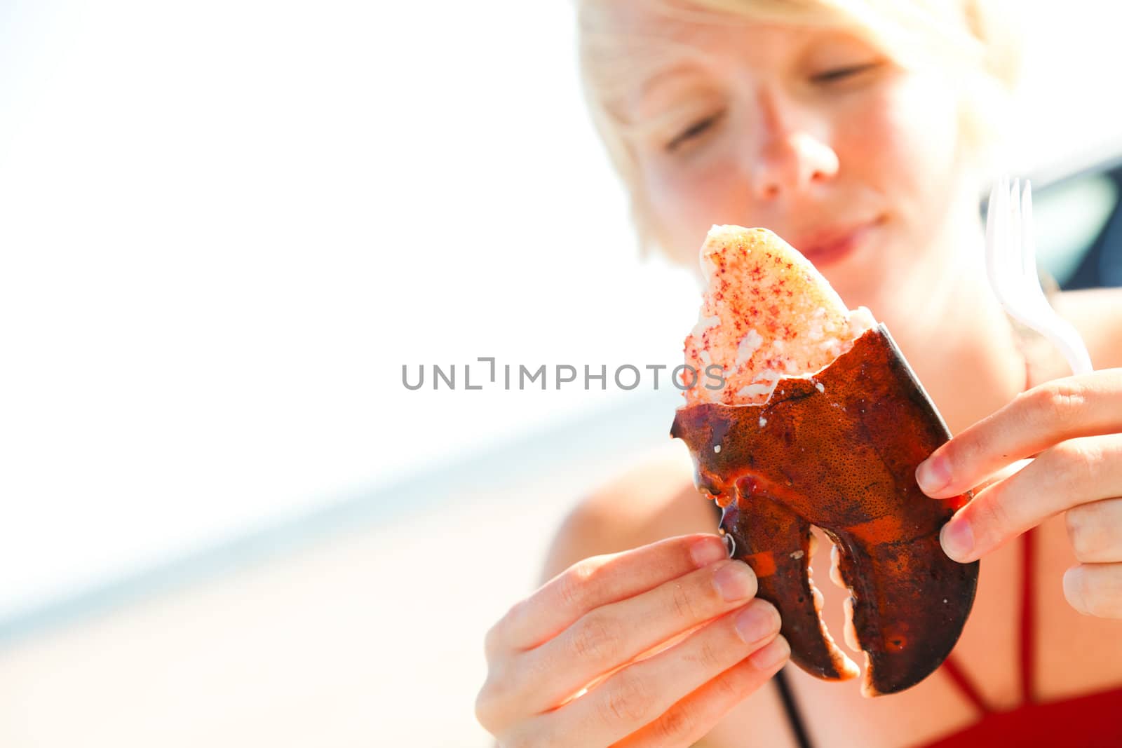 Girl holding a lobster claw outdoor with beautiful sunlight