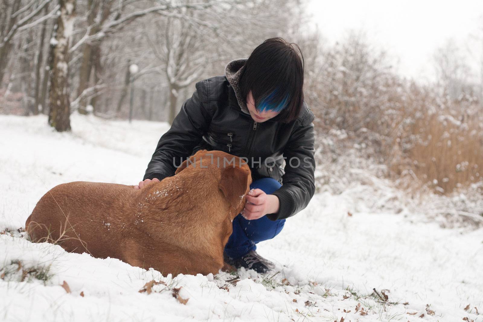 Funky boy is having fun with his dog in the snow