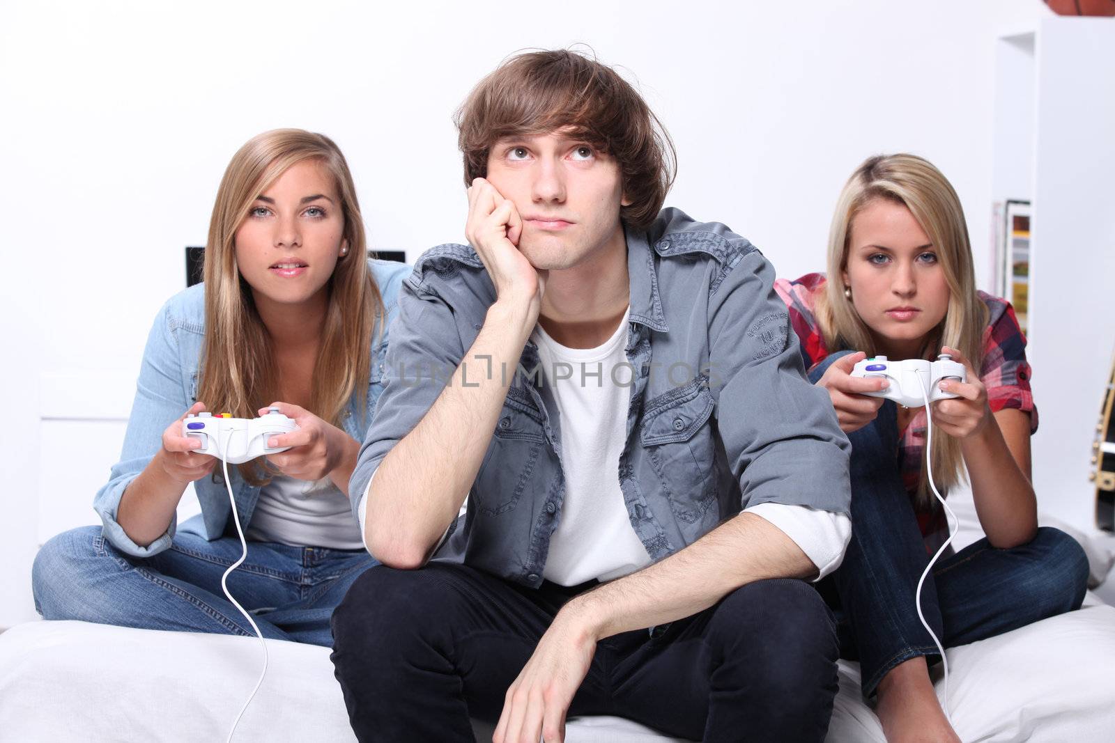 Three teenagers playing computer game by phovoir