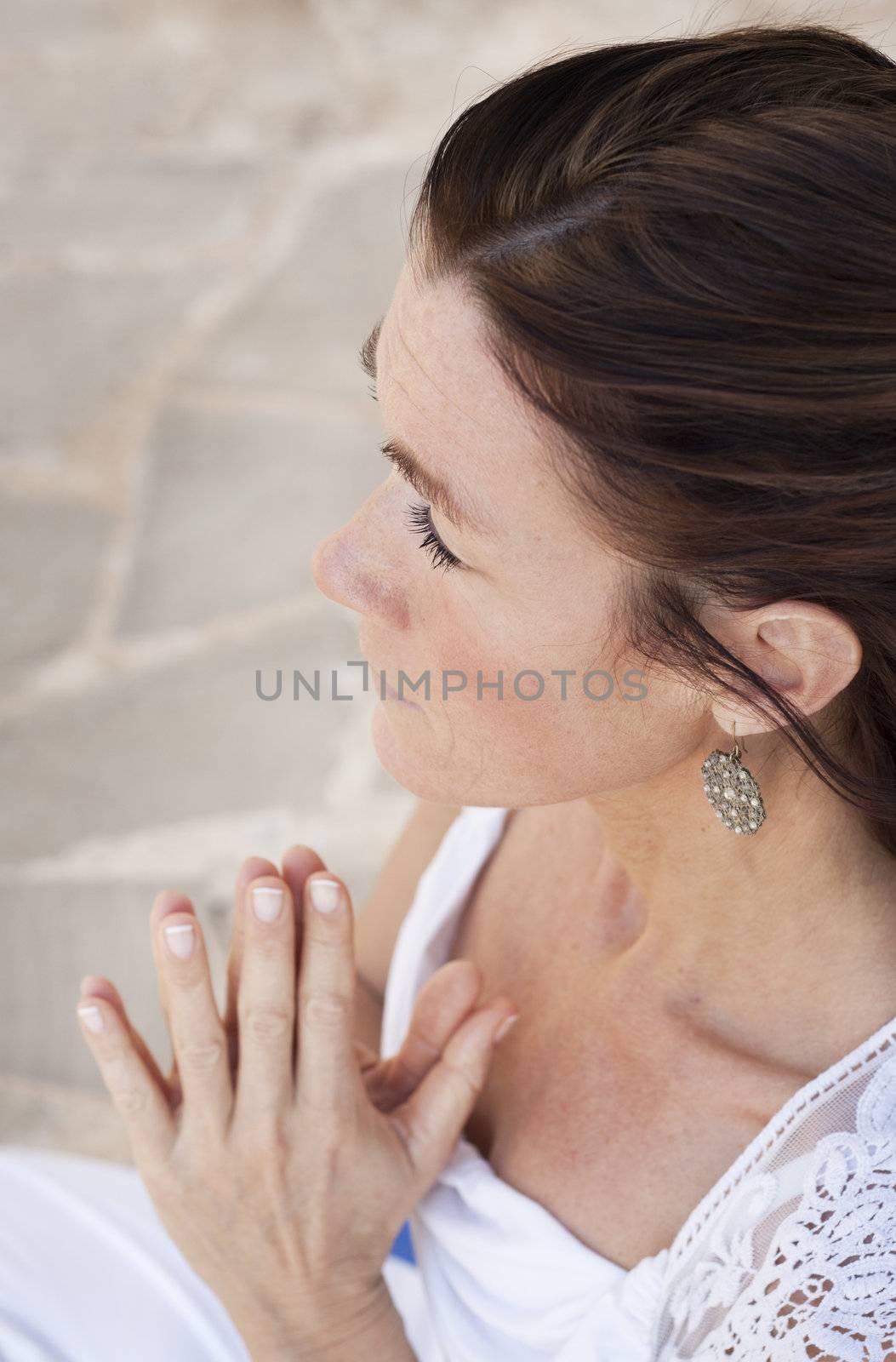 A senior lady doing yoga, holding her hands praying