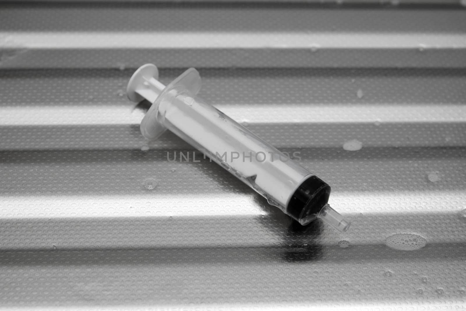 syringe on a metal surface by schankz