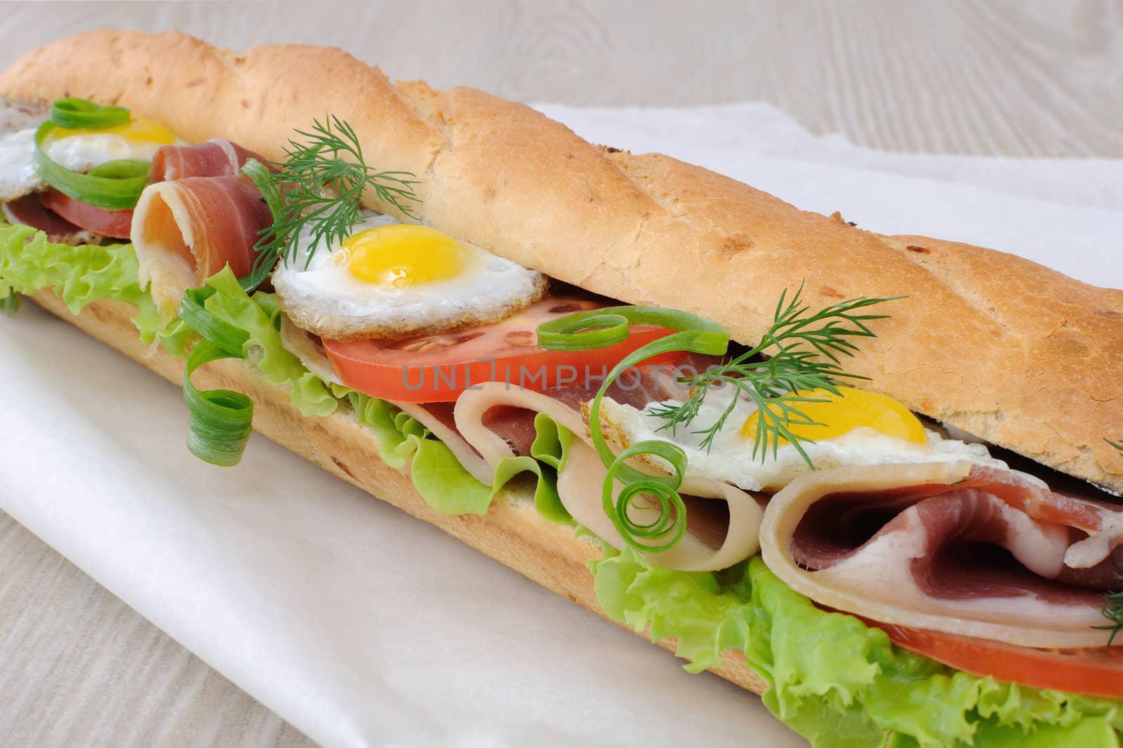 Big sandwich with ham, tomato and fried quail egg