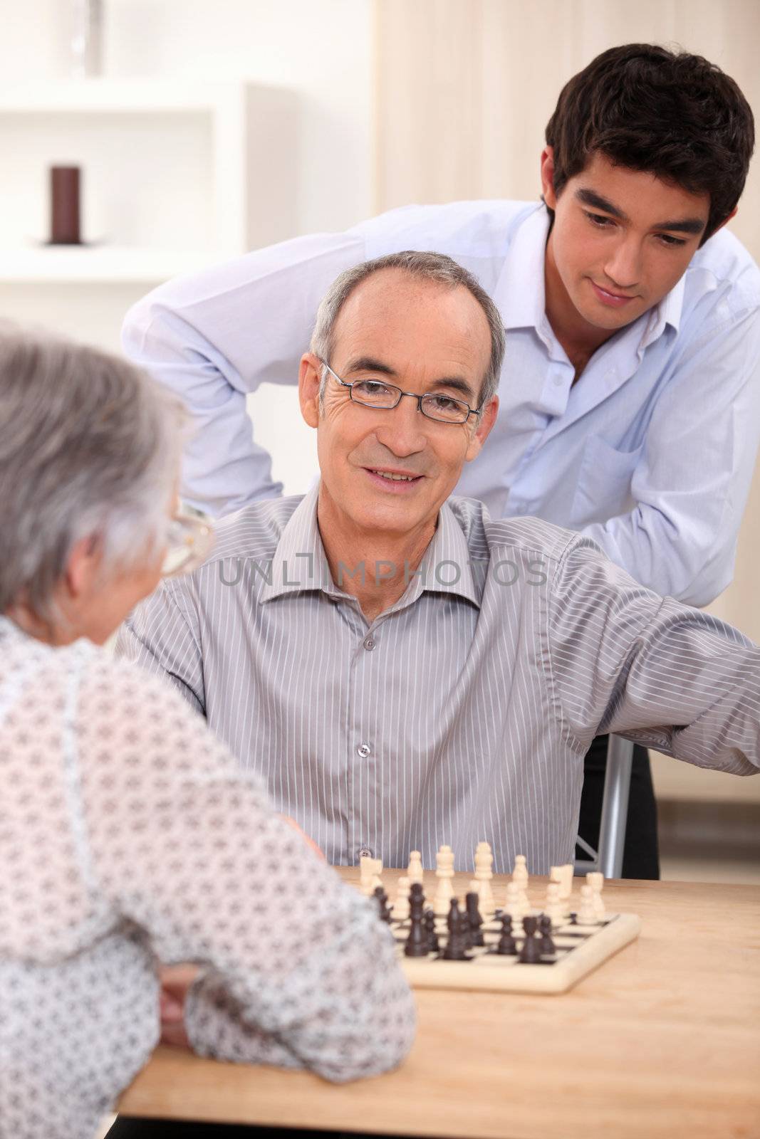 family playing chess by phovoir