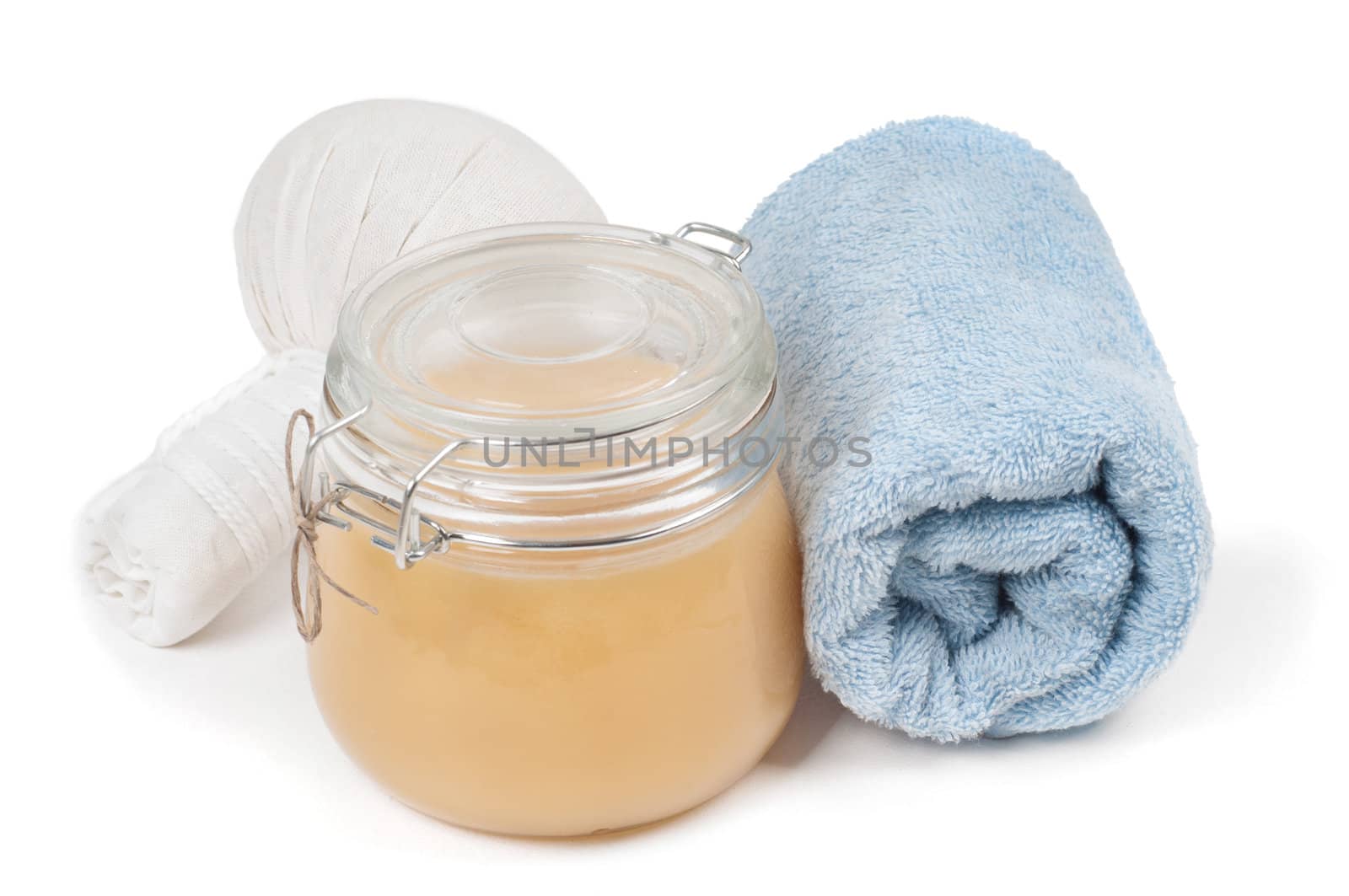Studio shot of spa accessories: honey, towel and herbal massage balls