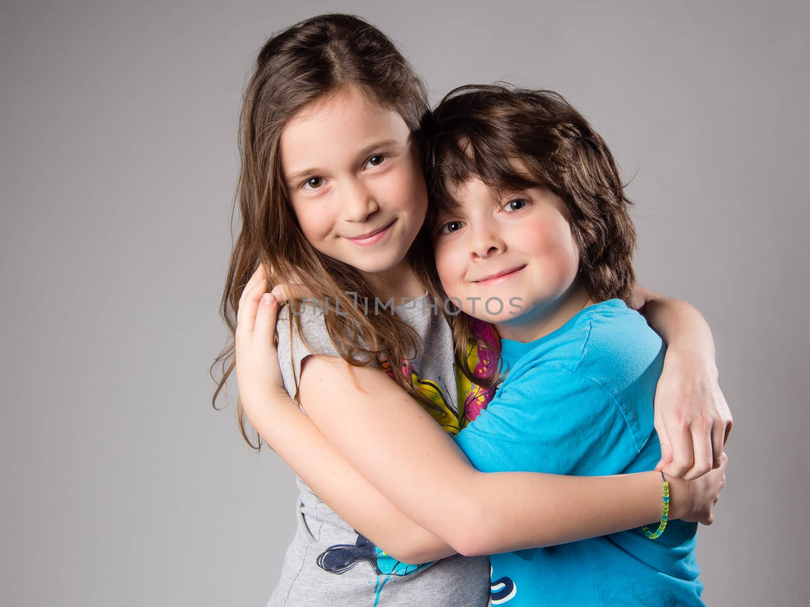 Brother and sister hugging in studio