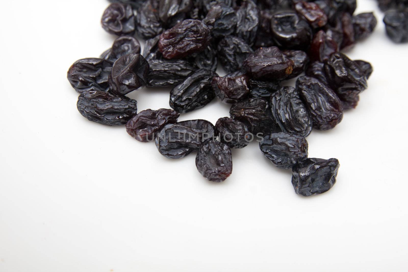 black raisins on a white background by schankz
