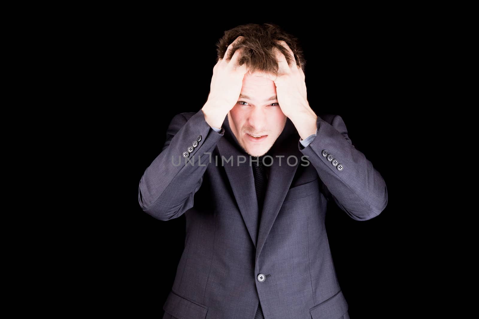 Angry businessman pulling hairs isolated on black background