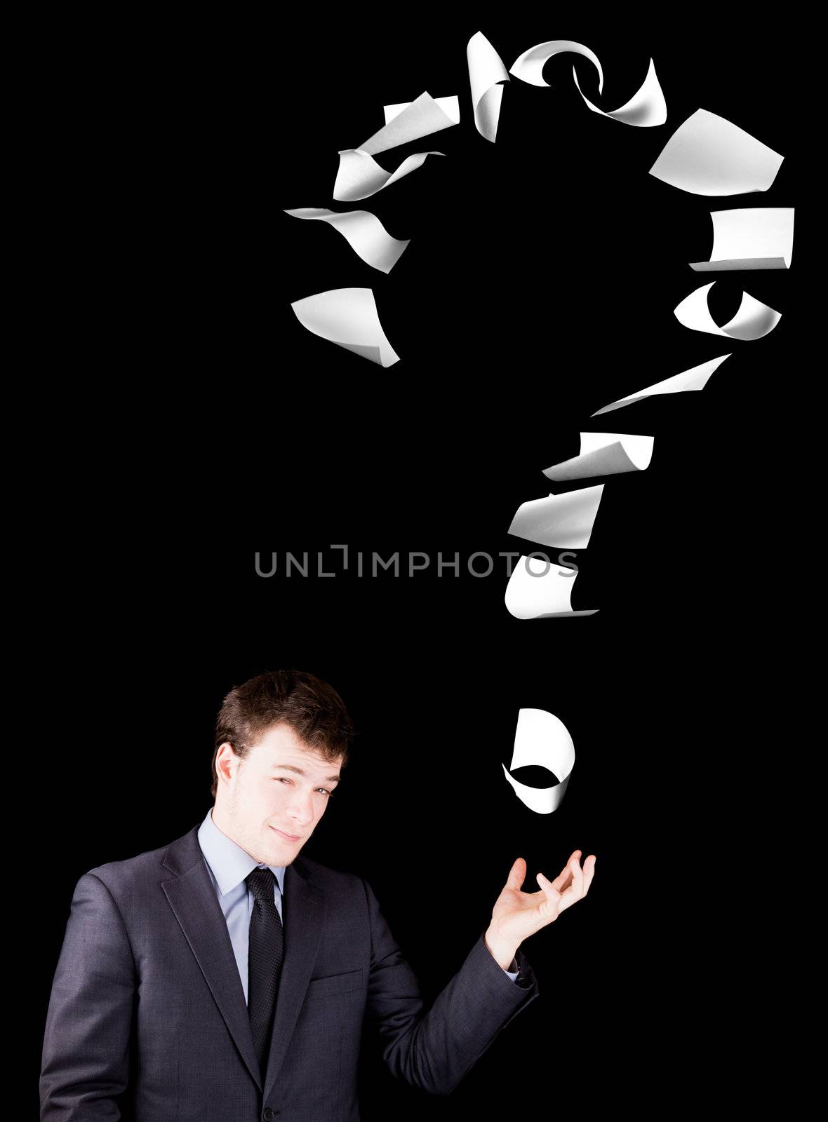 Businessman showing a question mark made of floating papers.