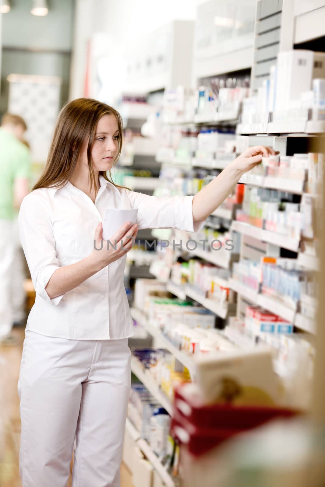 Attractive young pharmacist filling prescription