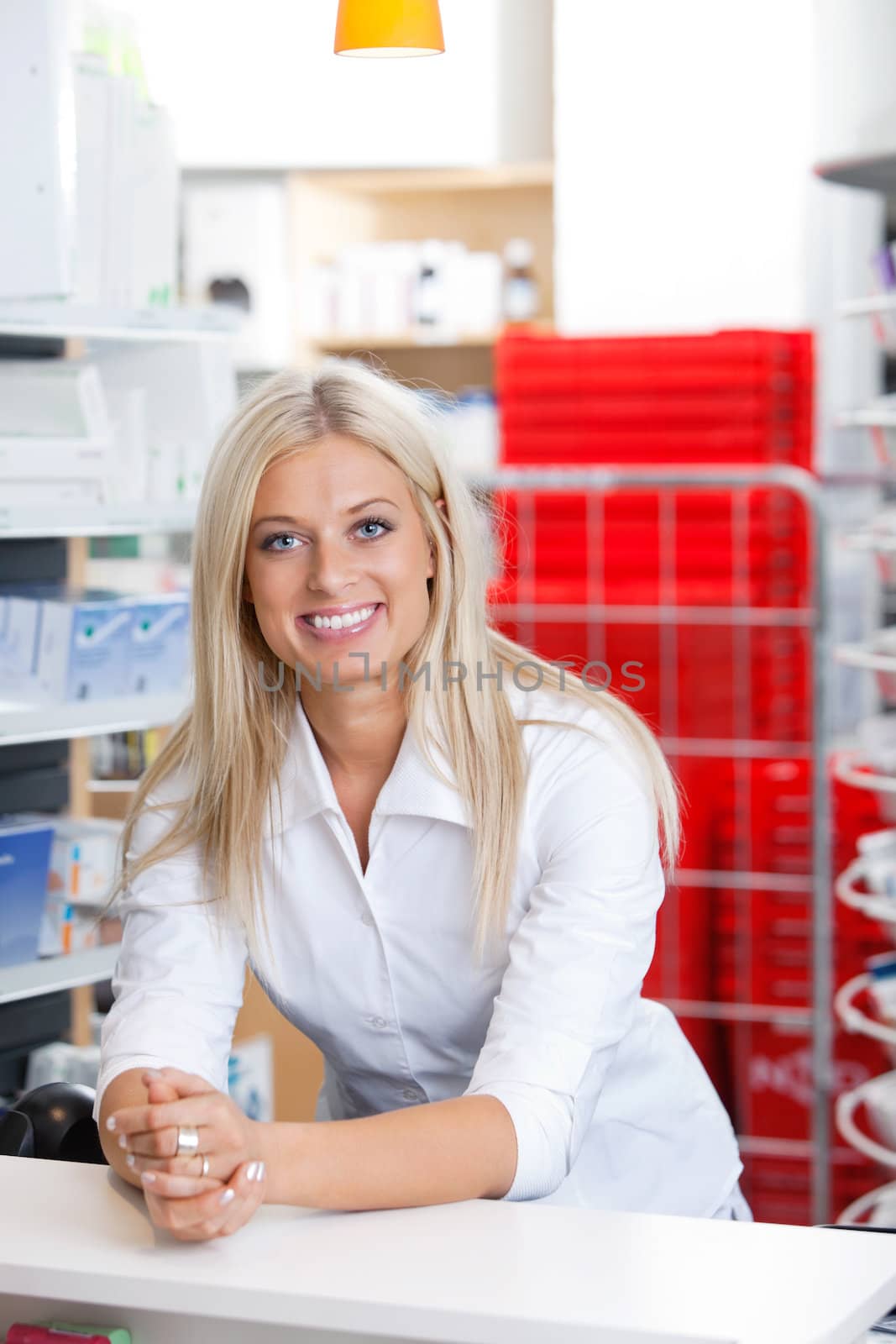 Portrait of smiling female chemist standing at counter