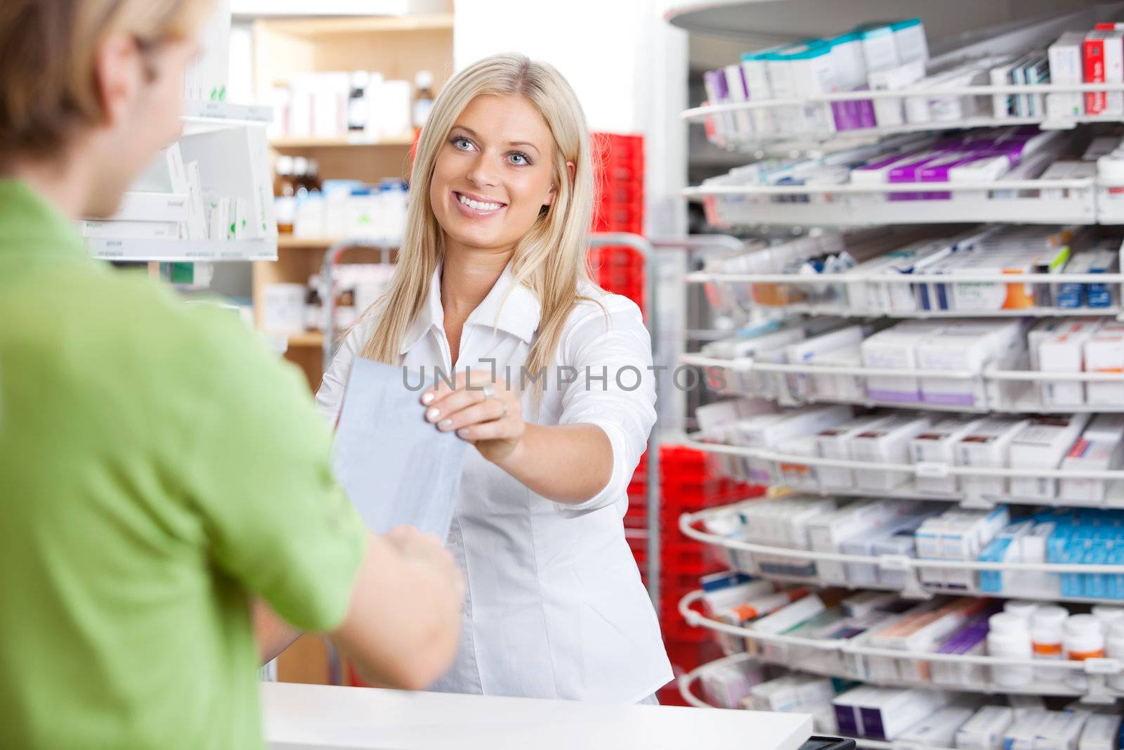 Female Pharmacist With Customer at Counter by leaf