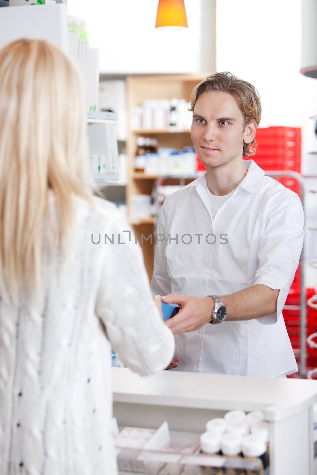 Male Pharmacist With A Female Customer In Pharmacy Drugstore.