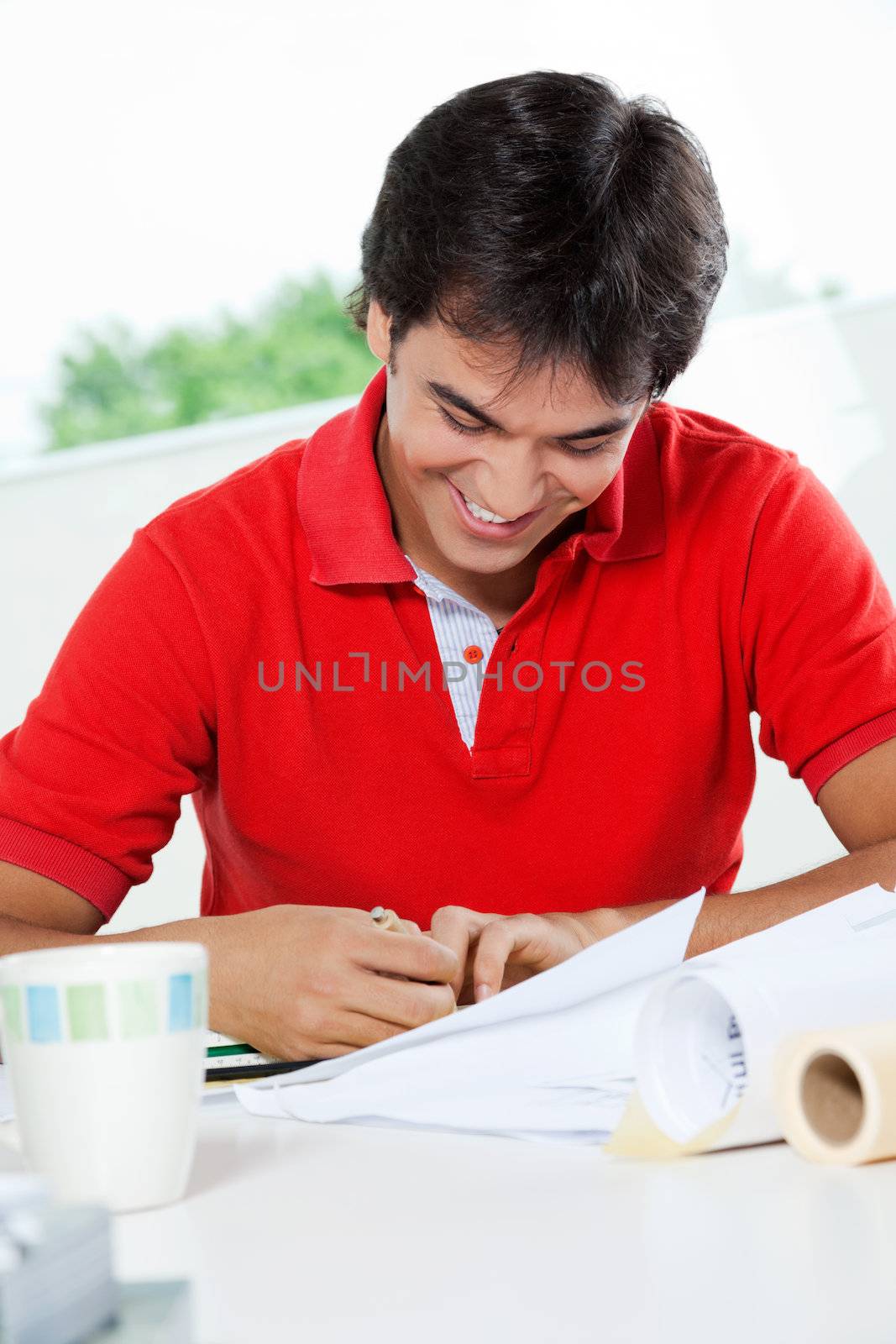 Male Architect Working On Blueprint by leaf