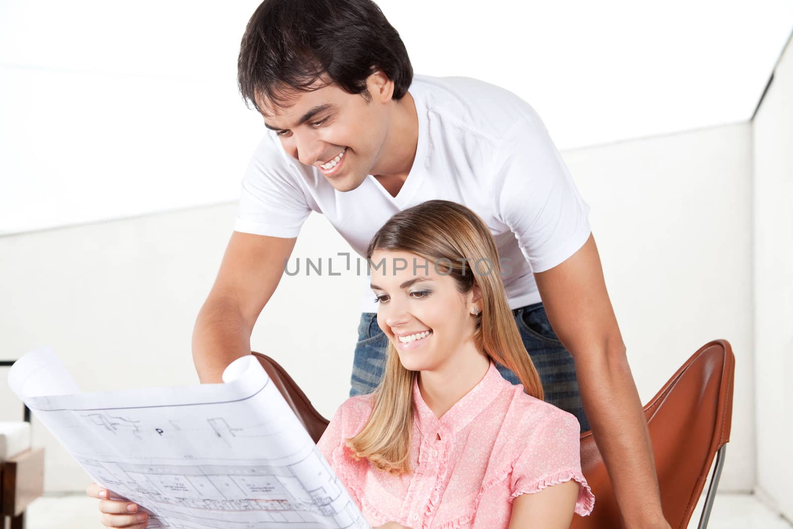 Young couple looking at blueprints at home.