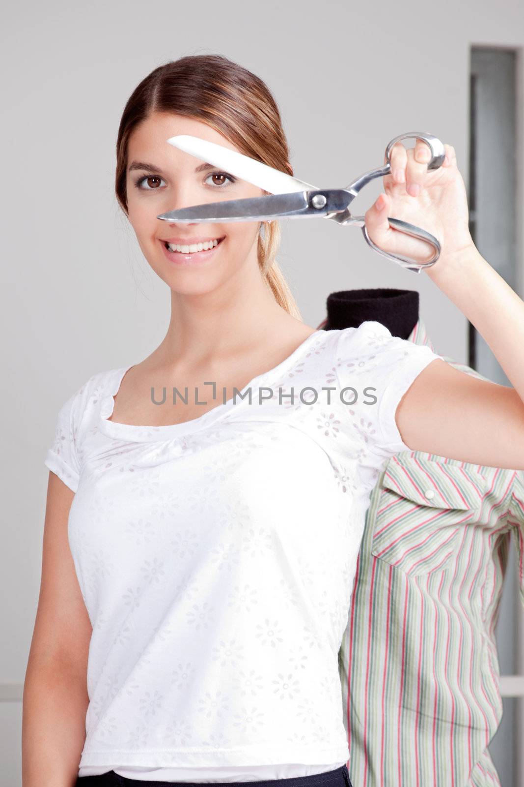 Female Dressmaker Holding scissors by leaf