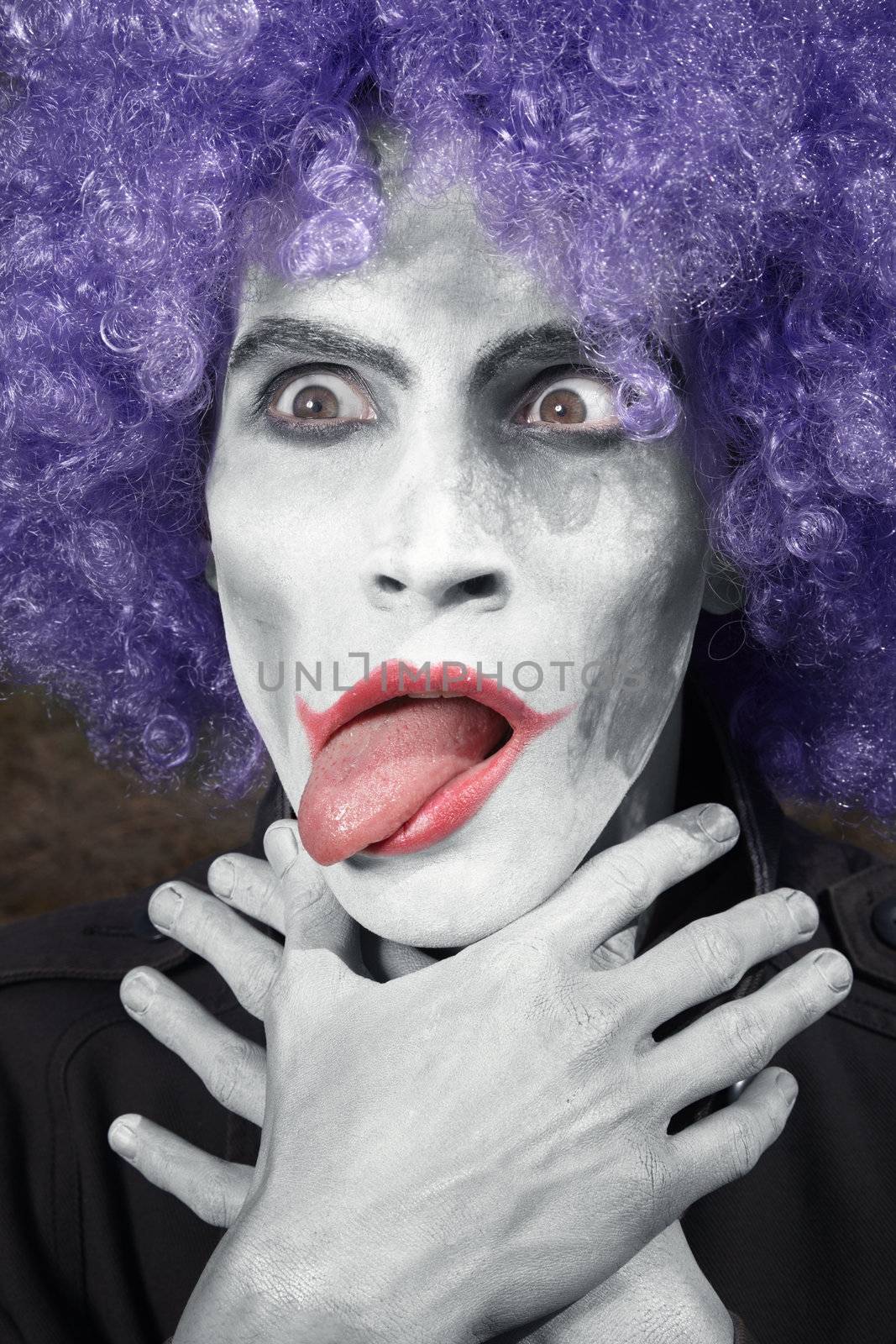 Crazy clown choking himself. Vertical photo. Artistic darkness and colors added