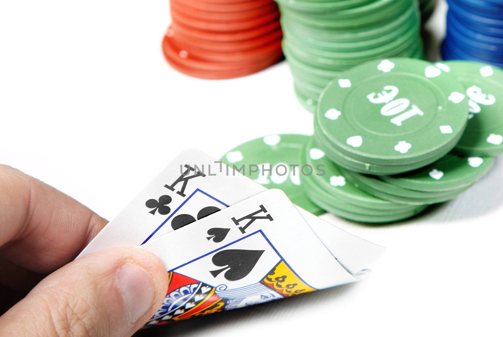 Pair of kings in human hand and poker chips on a white background