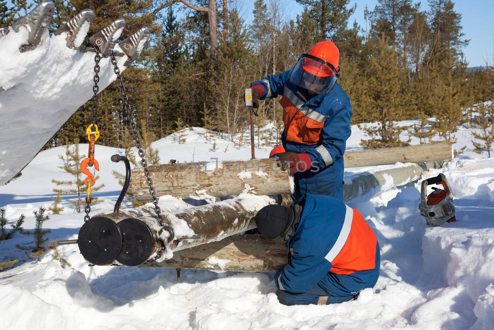 Installers collect a power pole in the snow by AleksandrN