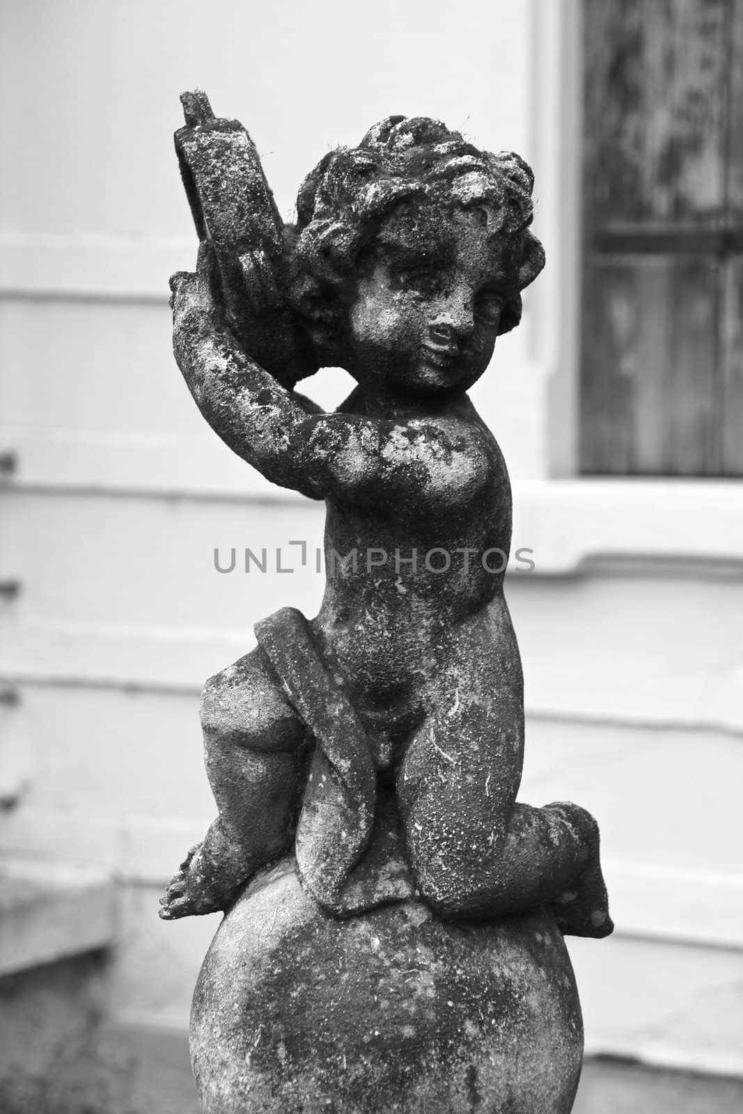 little angel playing the tambourine - old statue