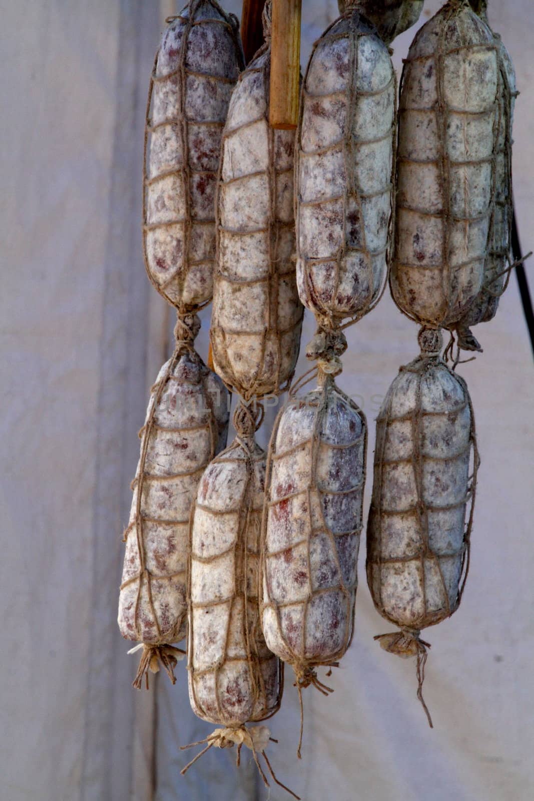 Row of flavoured hanging salamis, traditionally made from savoury pork and beef hung out to dry and cure
