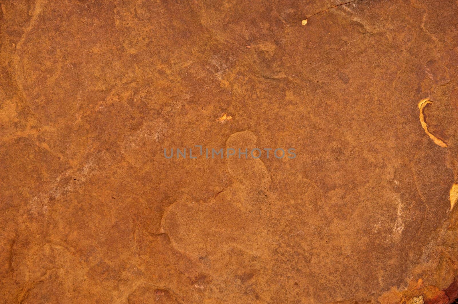 Rough stone background with cracks and pock marks on the surface of the rock