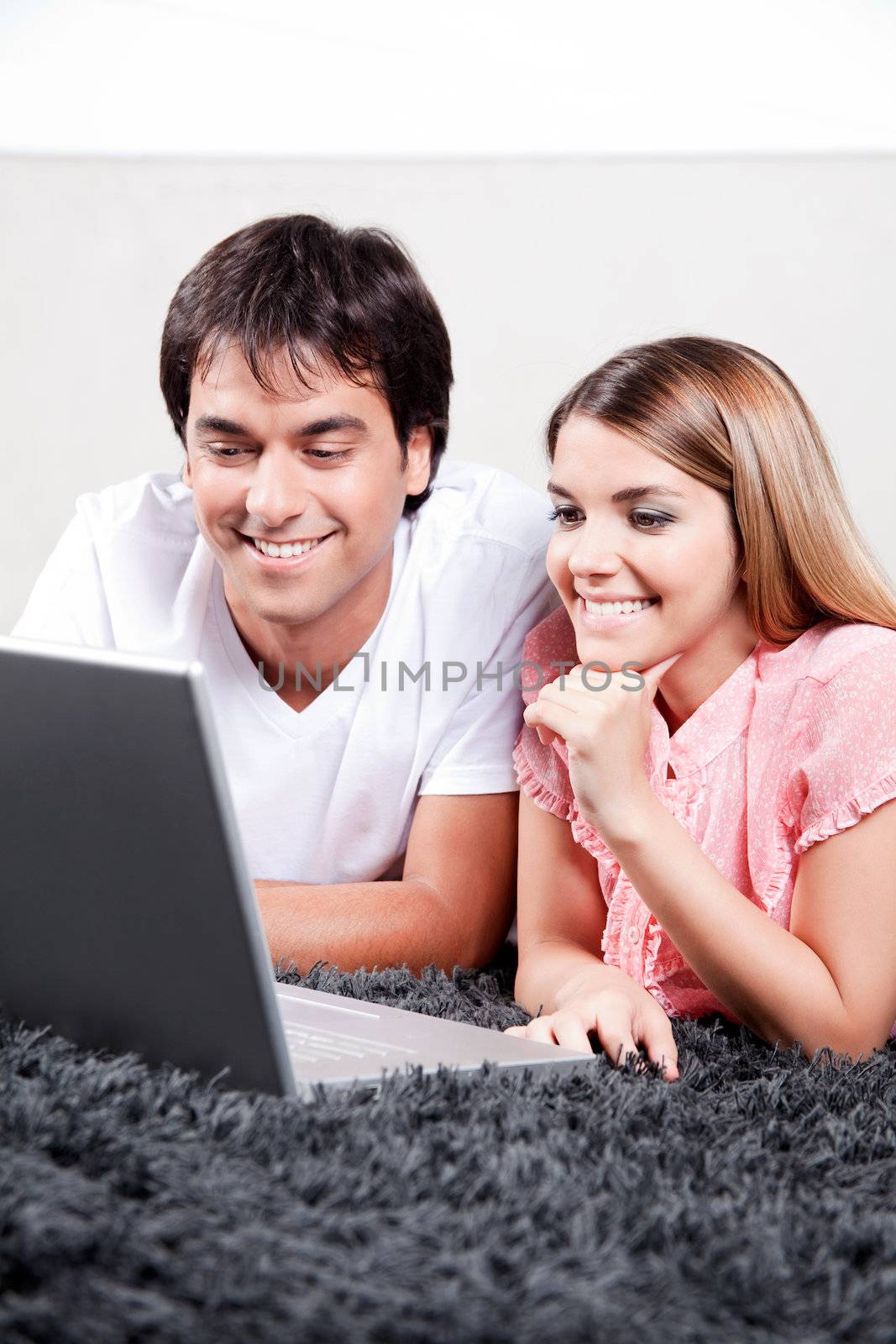 Young Couple Using Laptop by leaf