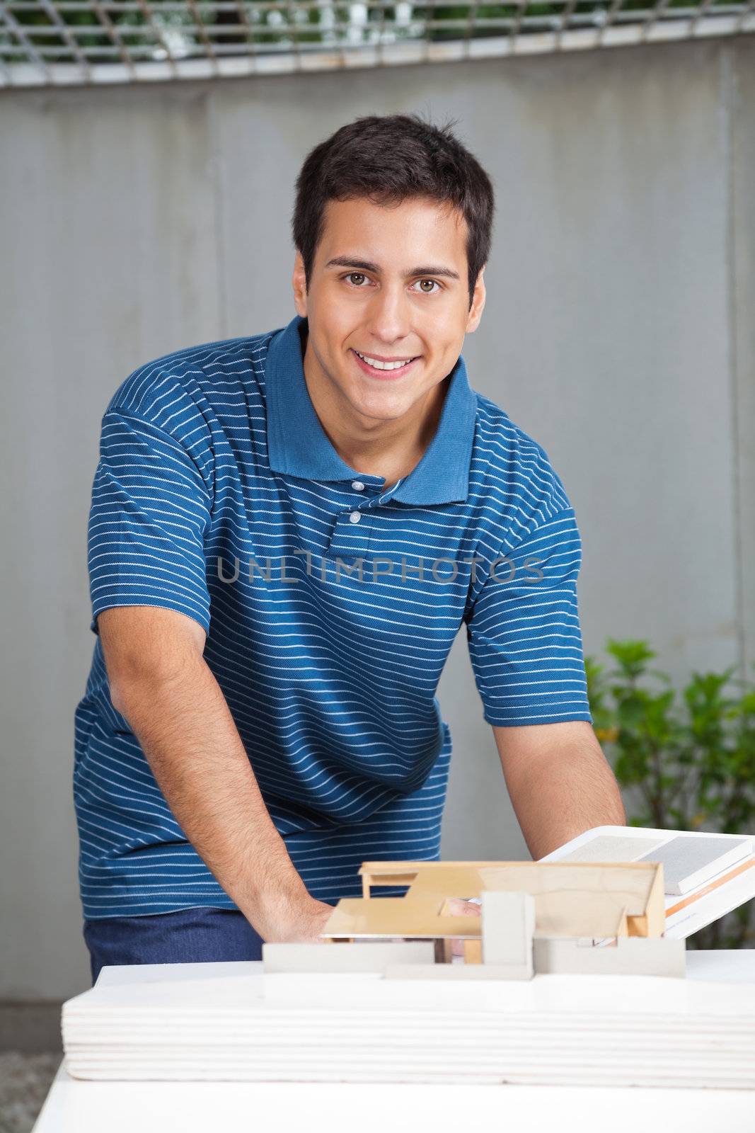 Portrait of young male architect in casual wear working on project