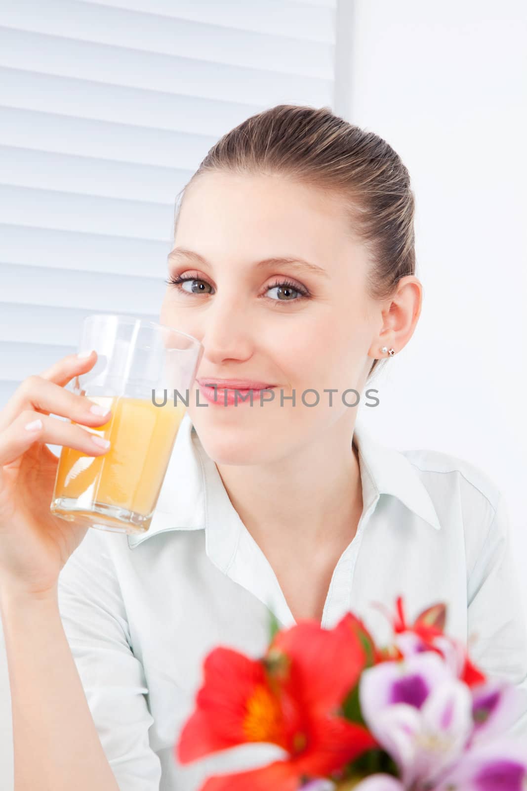 Young woman holding glass of juice.