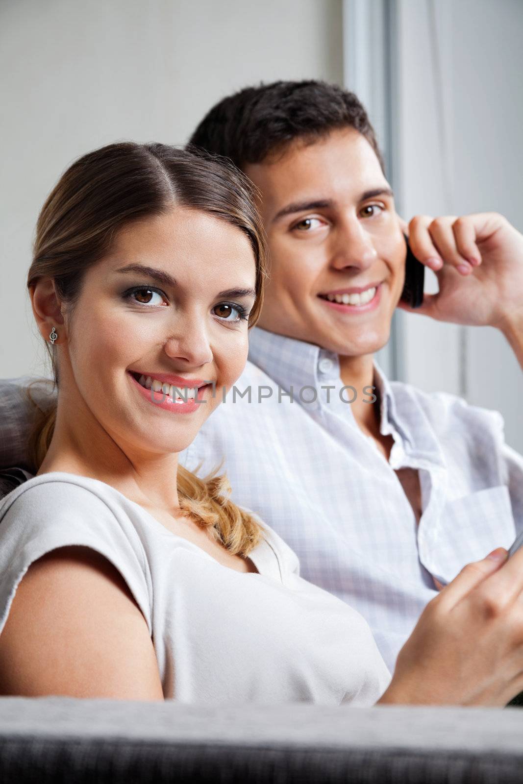 Portrait of beautiful young woman smiling with man on phone call