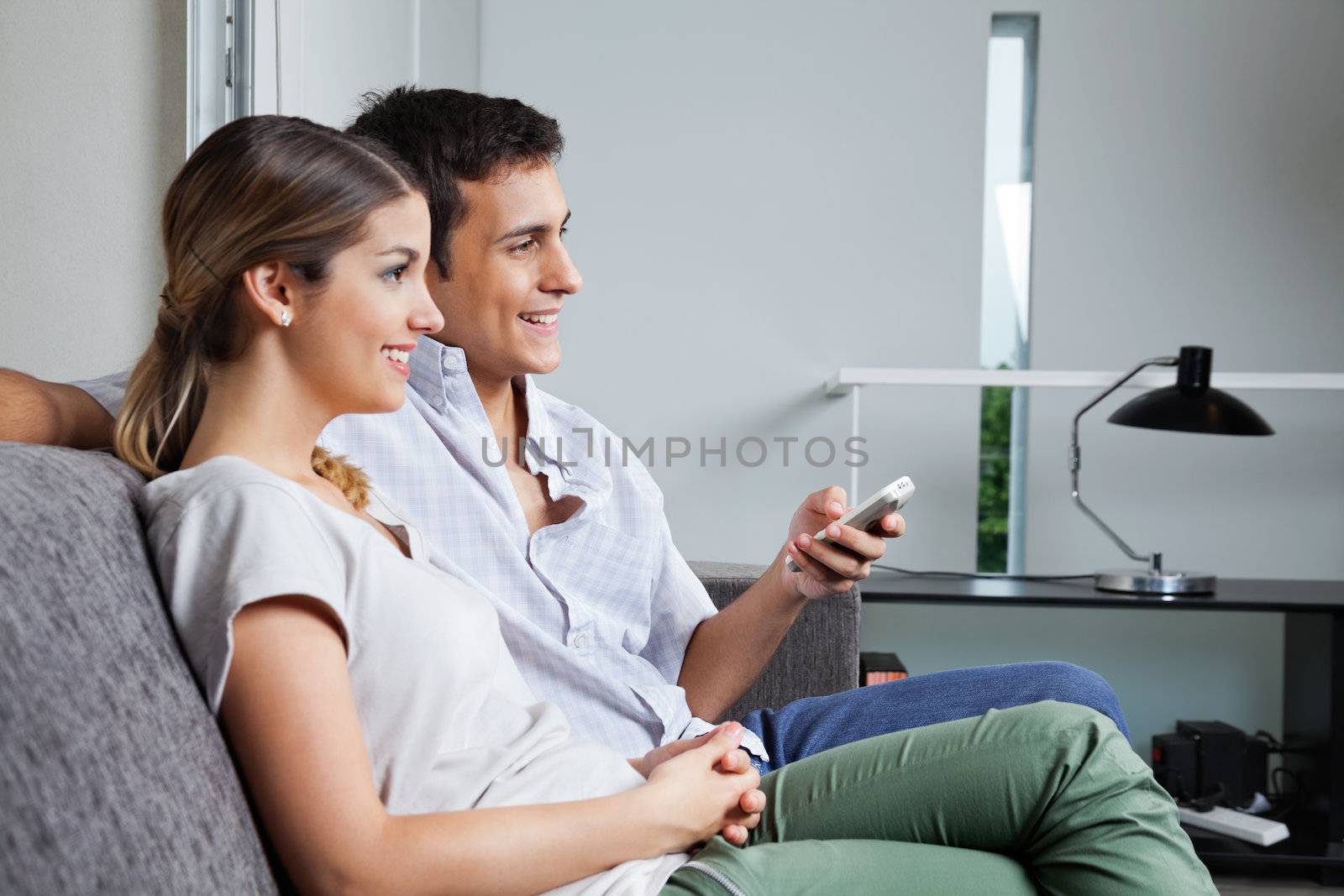 Couple Sitting Together On Sofa by leaf