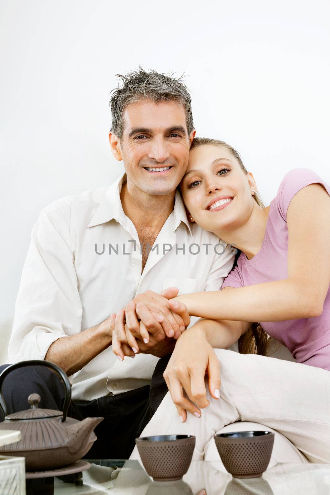 Portrait of happy couple sitting together while holding hands