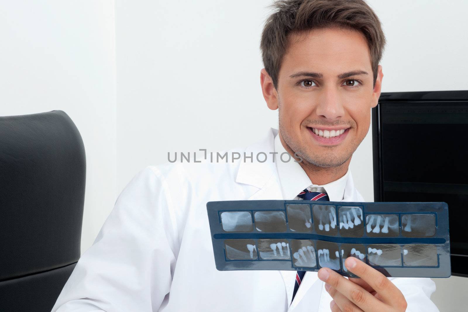 Male Dentist Holding X-Ray Report by leaf
