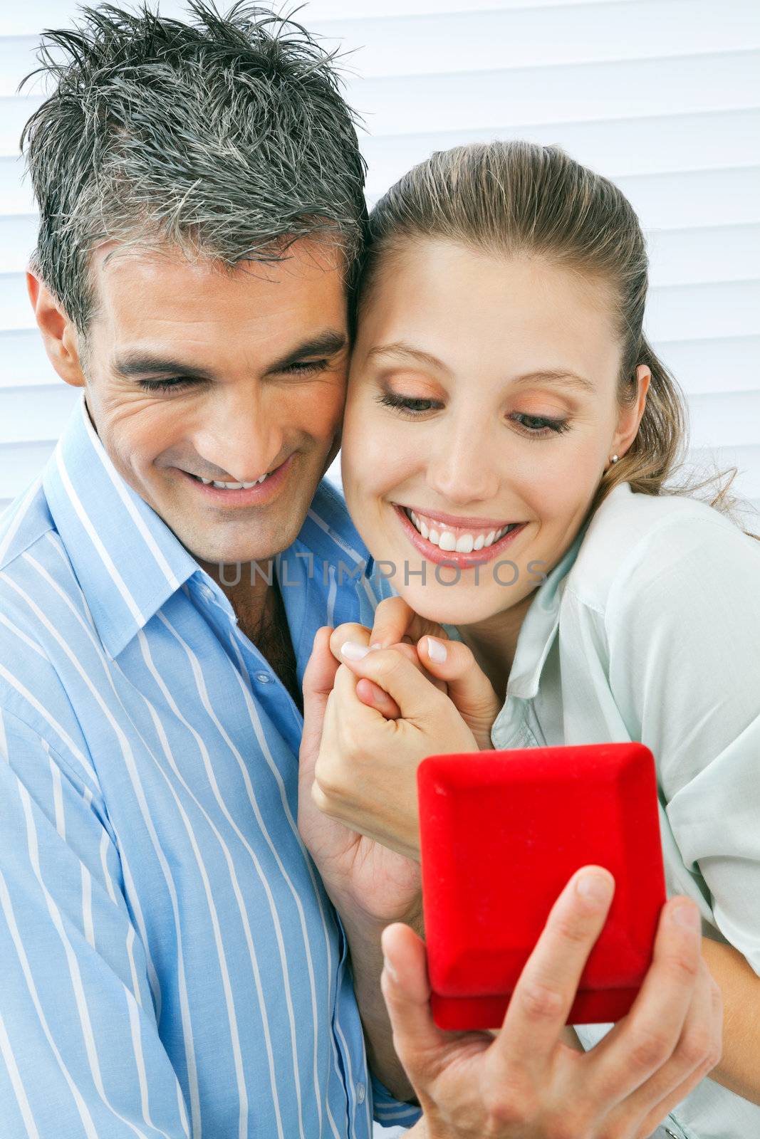 Middle aged man giving gift to happy woman holding a ring box