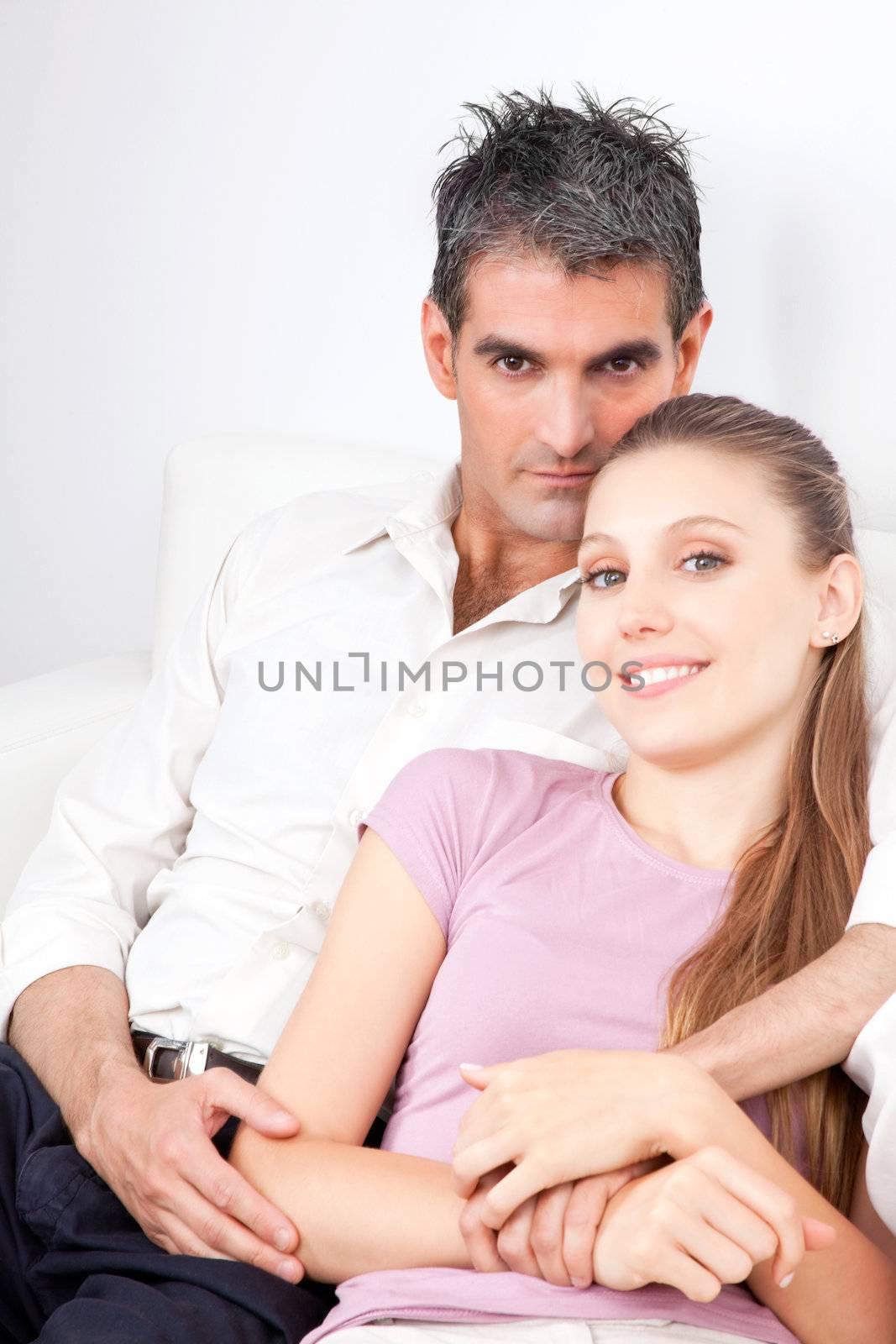 Portrait of young couple sitting on the couch .