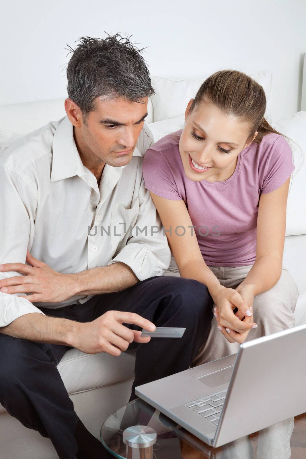 Couple using laptop and credit card to make an online payment