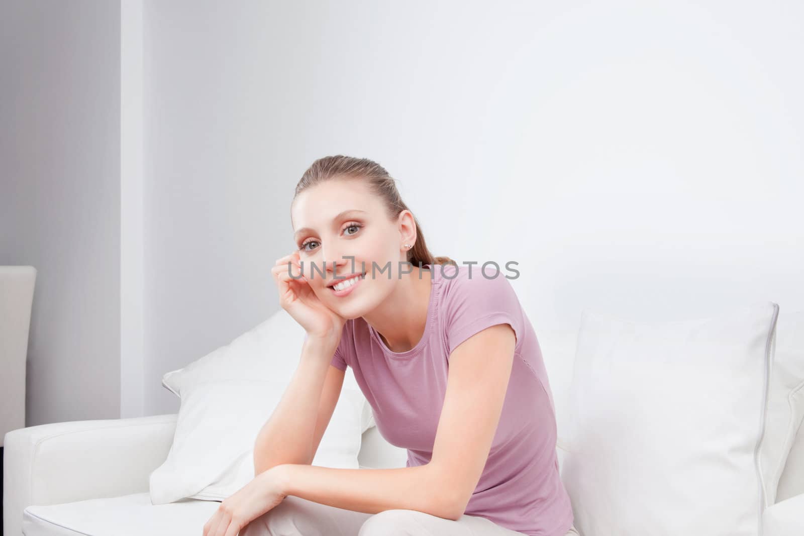 Happy young woman sitting on couch.