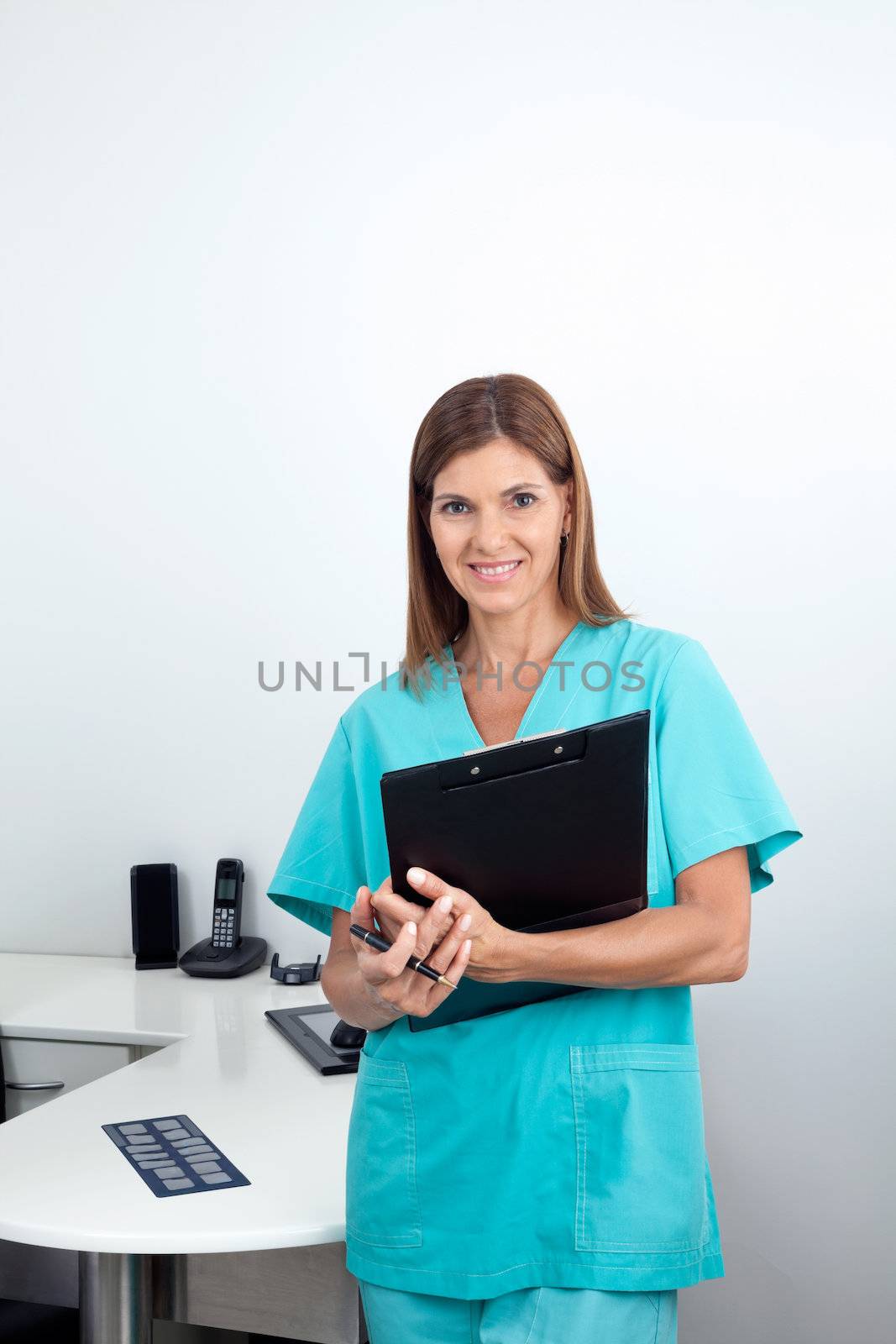 Female Dentist Holding Clipboard In Clinic by leaf