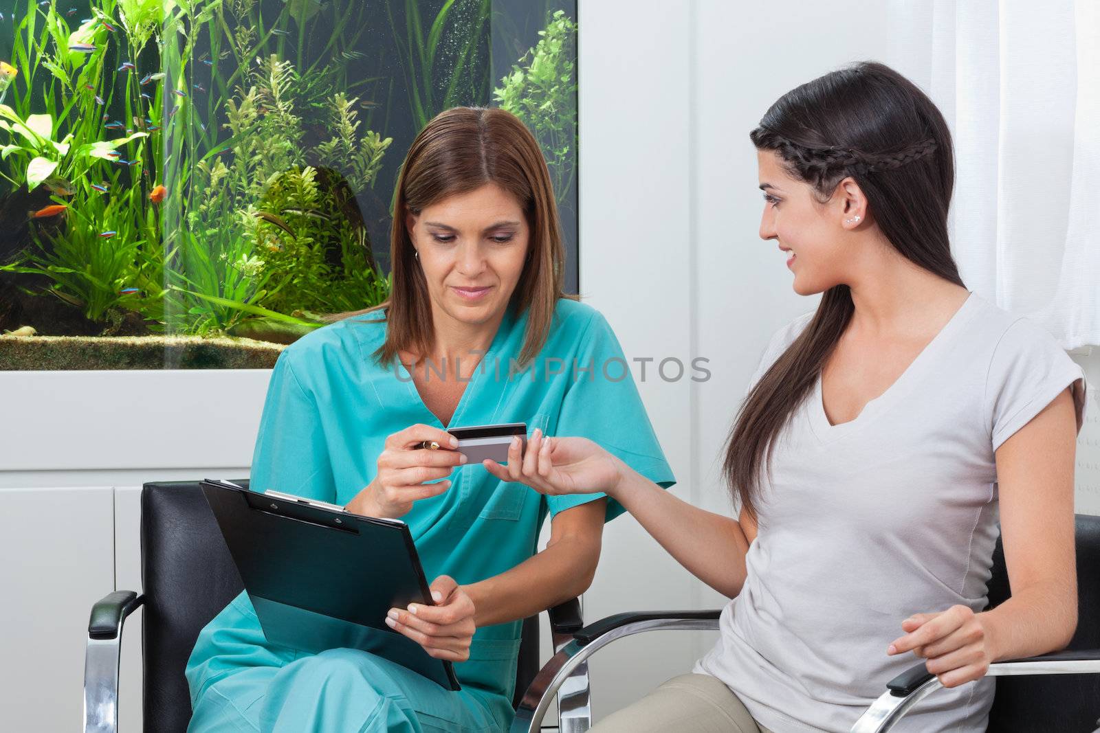 Woman Paying Through Credit Card To Dentist by leaf