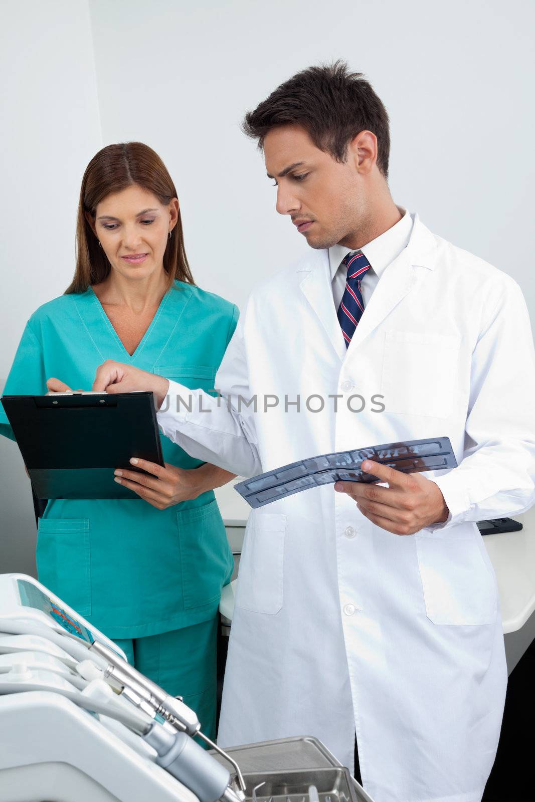 Doctor And Assistant Analyzing Patient's Report by leaf