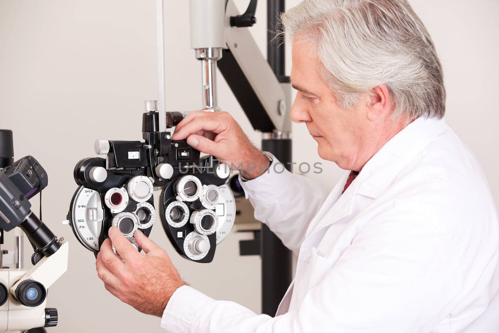 Doctor in ophthalmology clinic adjusting phoropter.