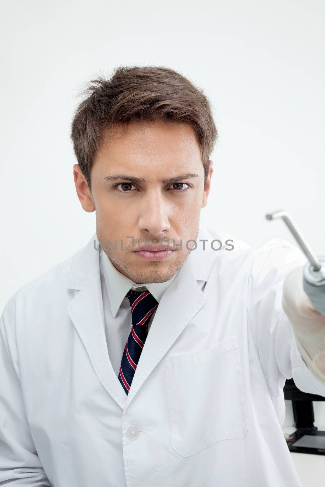 Portrait of male dentist holding water spraying tool