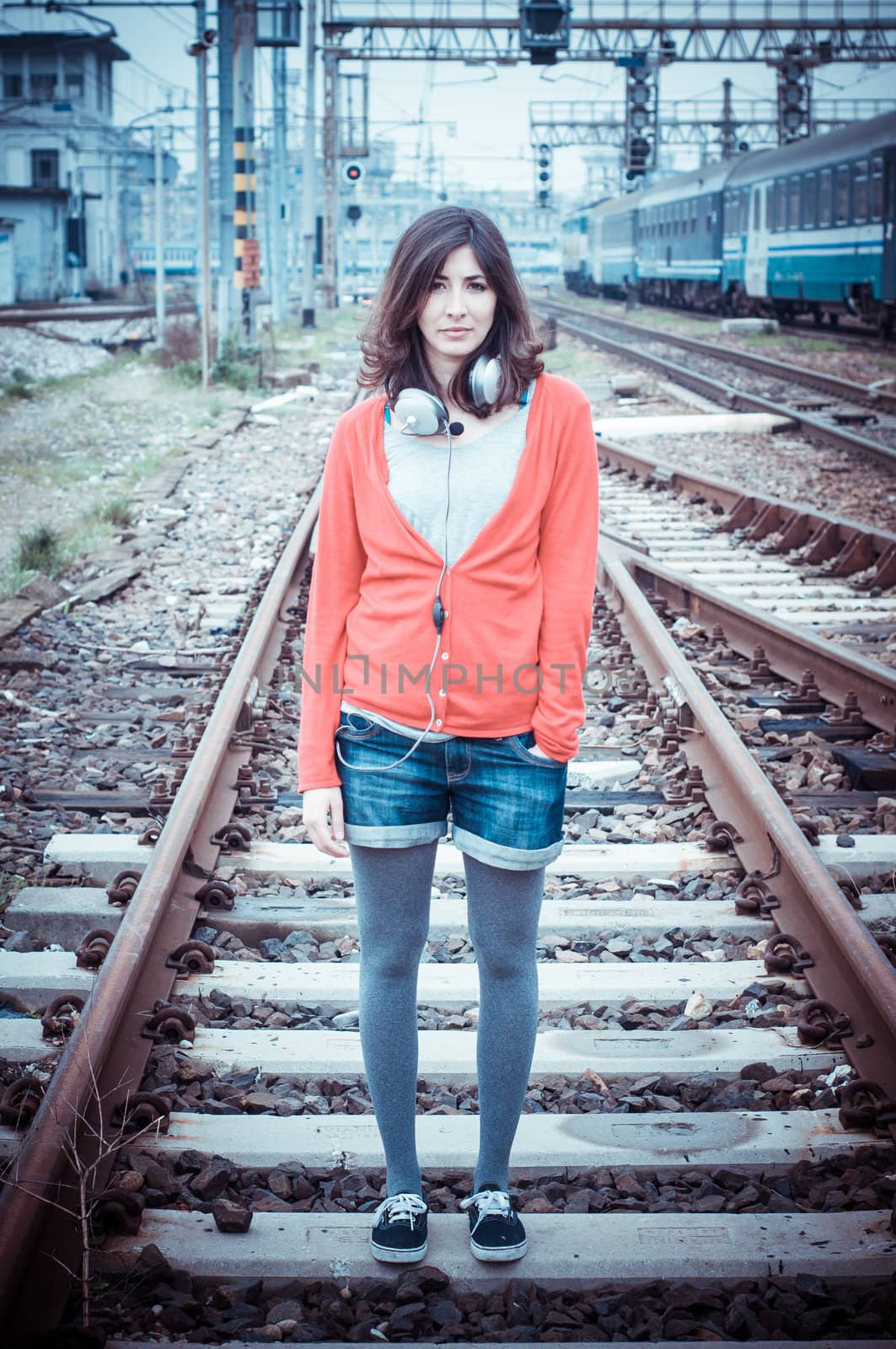 Beautiful stylish woman listening to music in railway