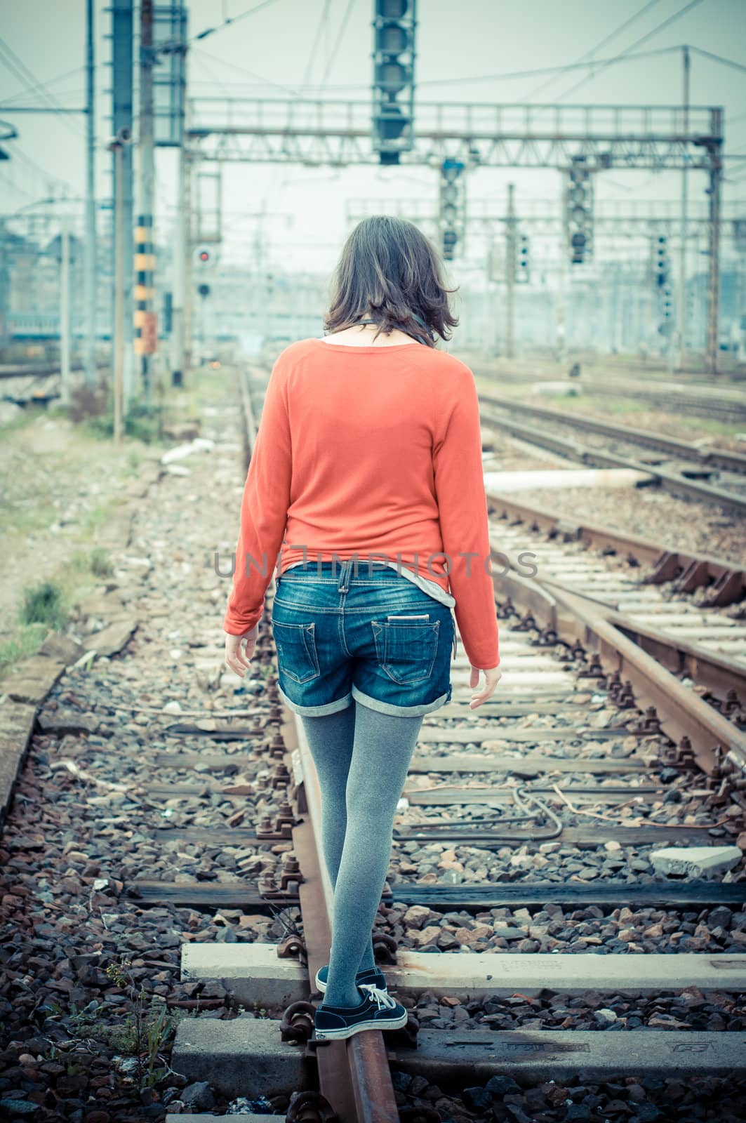 Beautiful stylish woman listening to music in railway