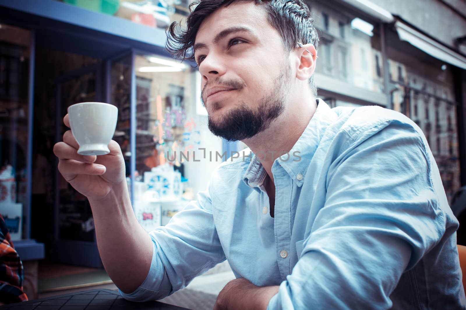 stylish man drinking a coffee at the bar in the city