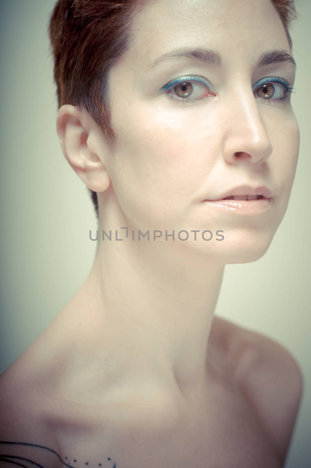 beautiful girl with short red hair on gray background