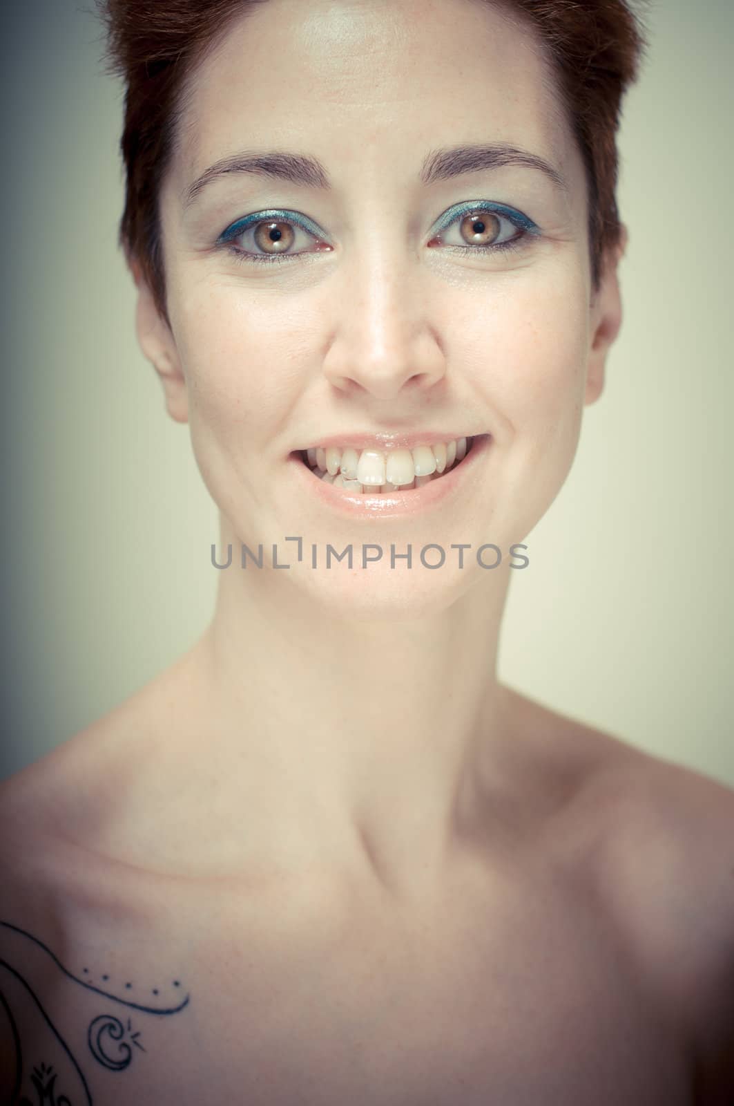 beautiful girl with short red hair on gray background