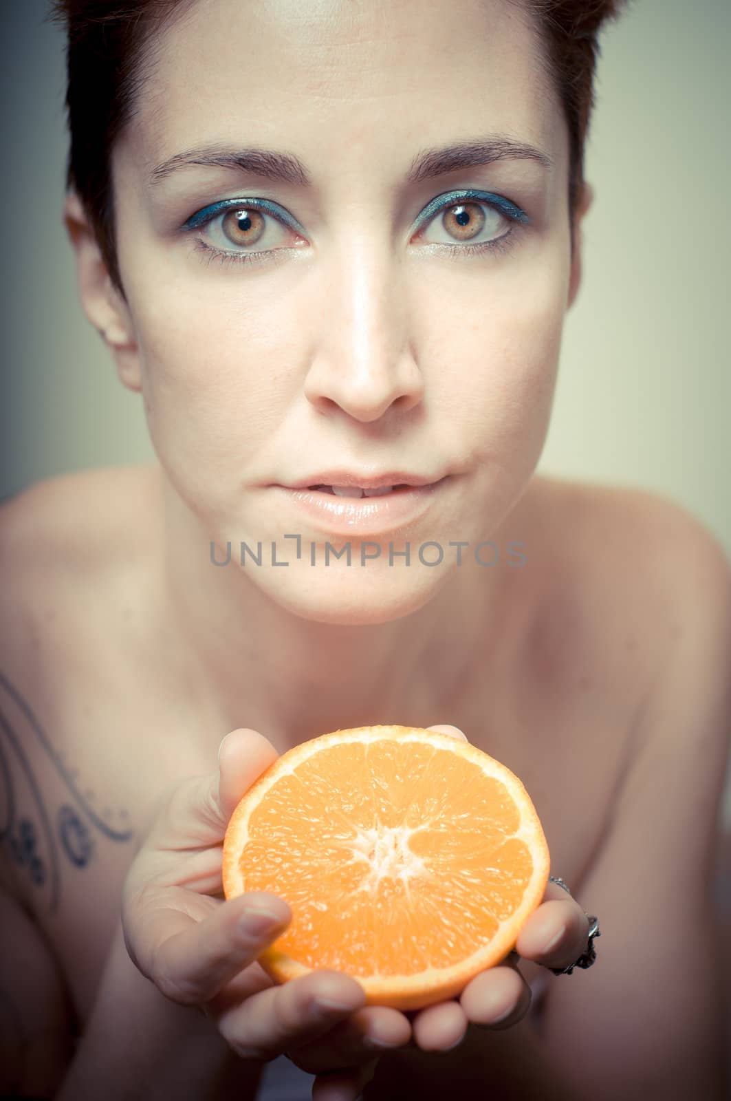 beautiful girl with short red hair and fruit on gray background