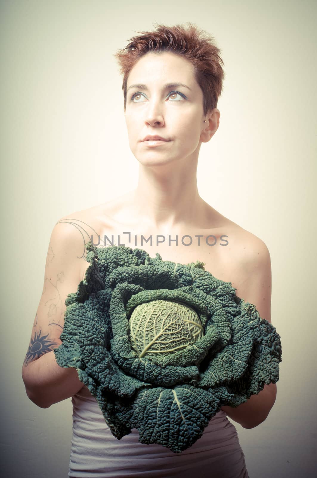 beautiful girl with short red hair and vegetable on gray background