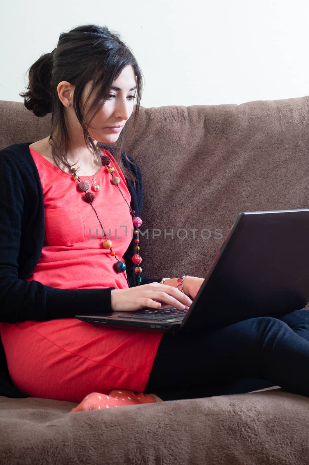 woman at home using notebook on couch